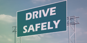 Road sign displaying the words Drive Safely against a cloudy sky
