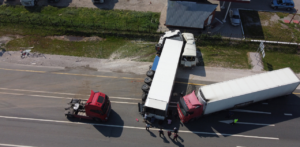 Aerial view of multi-truck collision blocking highway with emergency response