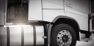 Close-up of semi truck fuel tank and rear wheel, highlighting commercial trucking and diesel transport industry