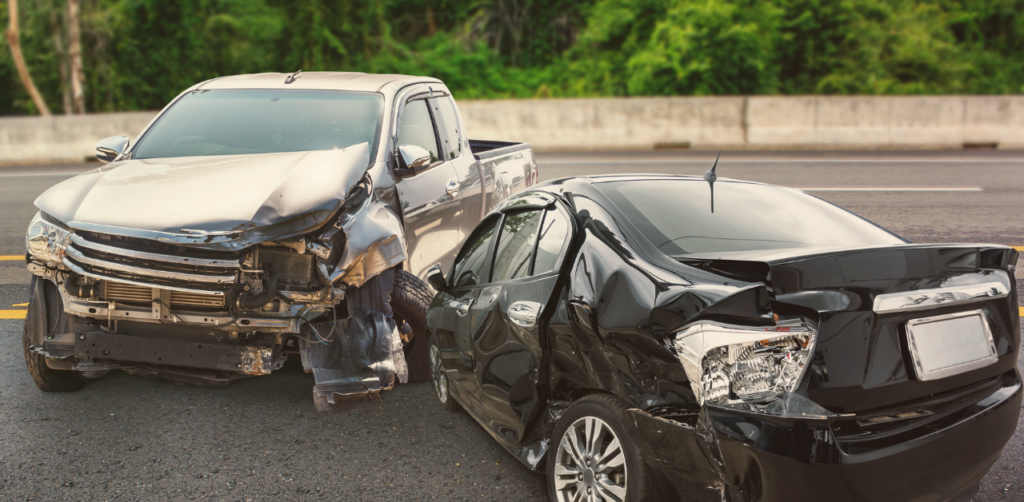 Damaged pickup truck and sedan remain at the scene of a serious traffic collision